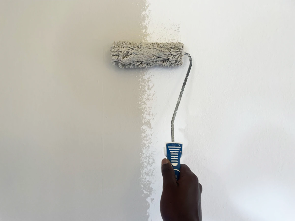 Professional painter rolling fresh paint onto an interior wall